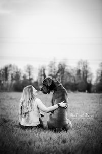 Foto-Deutsche-Dogge-mit-Besitzerin-sitzend-und-anschauend-schwarz-weiss